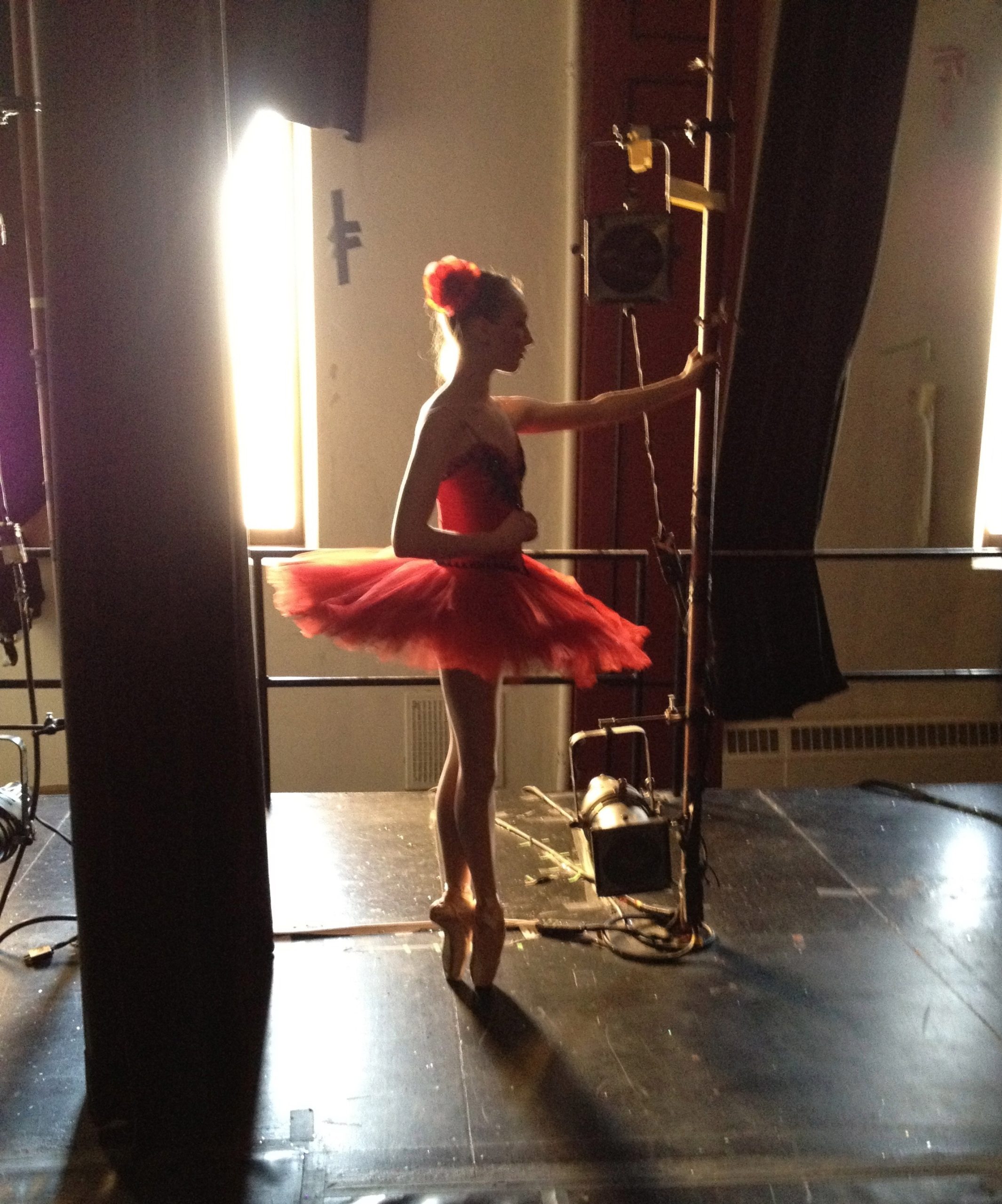 Close-up of ballet dancer tying pointe shoes before class, symbolizing discipline and professional ballet training at North Central Ballet.